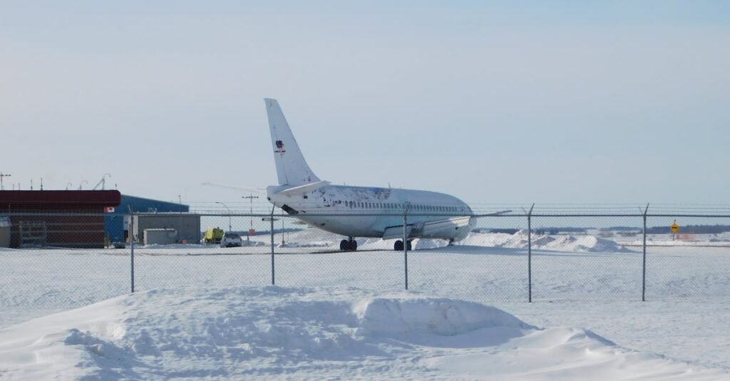 American Airlines parked on a snowy runway at an airport, captured in winter conditions.