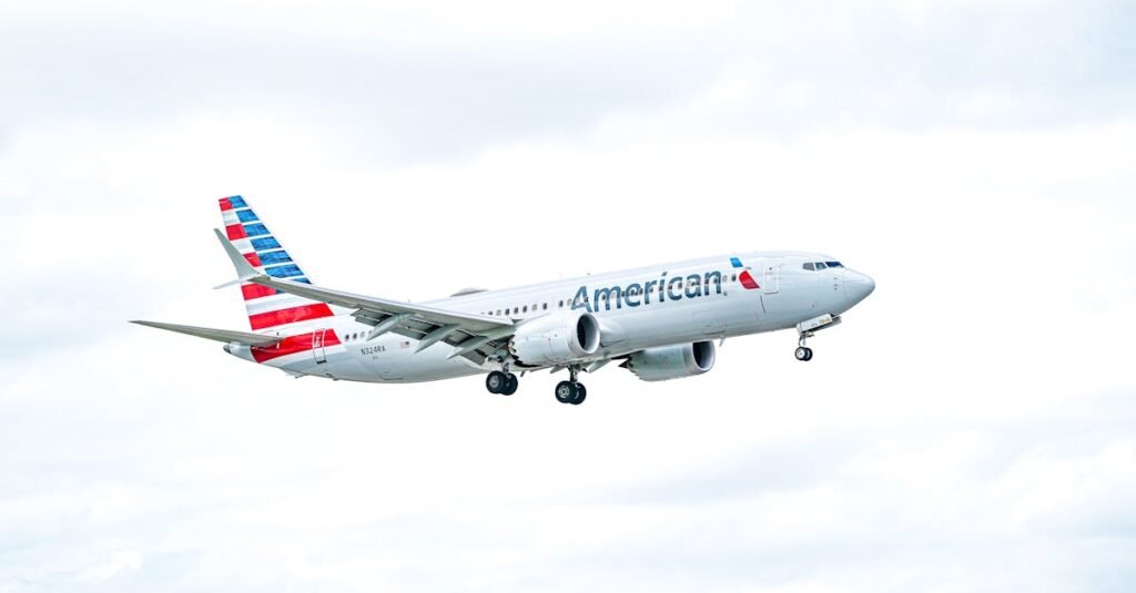 An American Airlines aircraft flying against a bright, cloudy sky, showcasing aviation excellence.