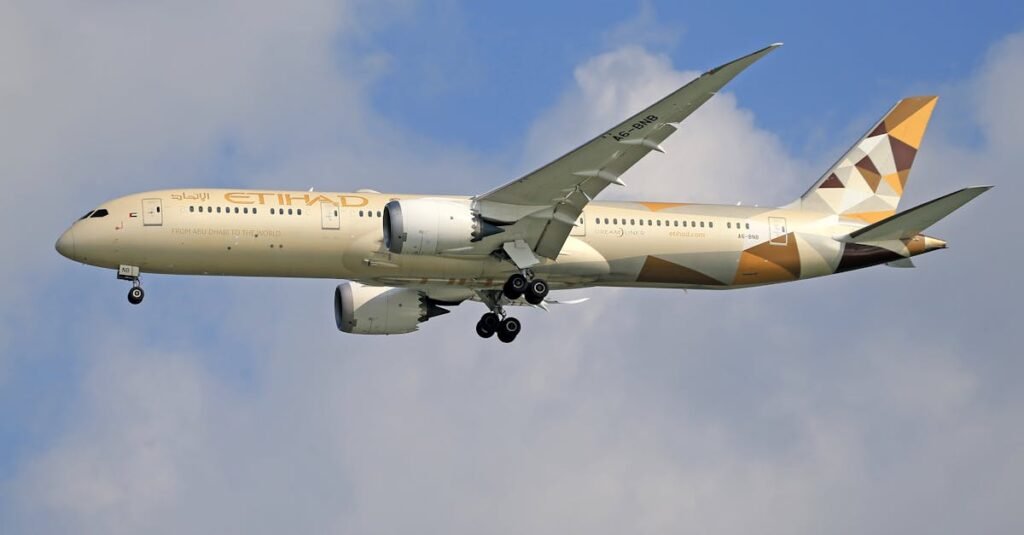 Etihad Airways Boeing 787 flying against a blue sky, showcasing aerodynamic design.