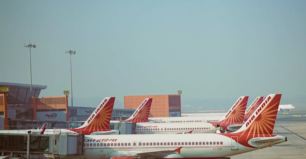 A fleet of Air India airplanes parked on the runway at an airport under clear blue skies.