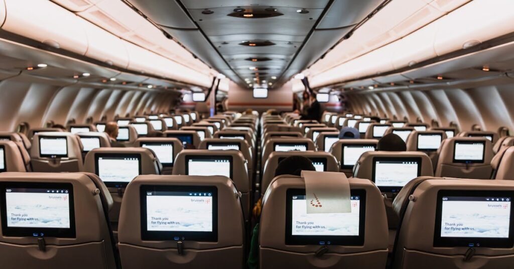 pexels-photo-16562837-16562837 Comfortable airplane cabin interior featuring in-flight entertainment screens on all seats.