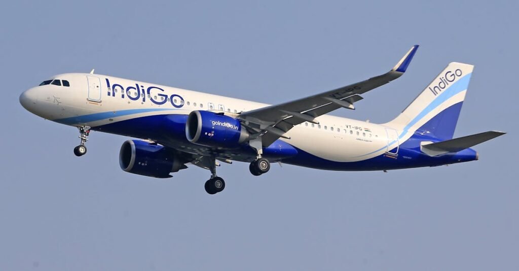 IndiGo commercial airline flying against a clear blue sky, signifying travel and aviation.