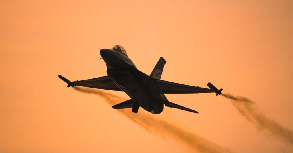 An F-16 jet flies silhouetted against an orange sunset sky, displaying a dramatic scene.