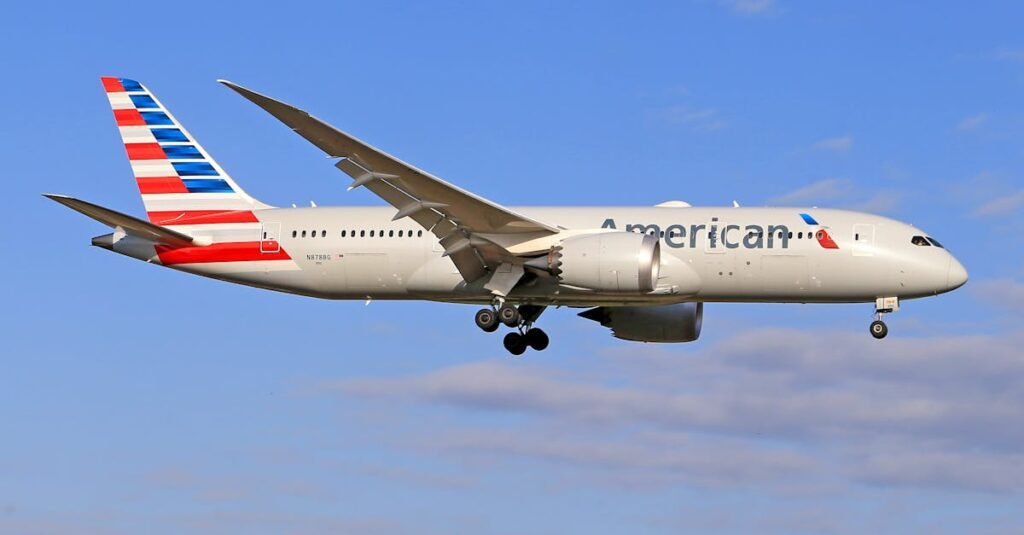 American Airlines Boeing 787 Dreamliner soaring through a clear blue sky.