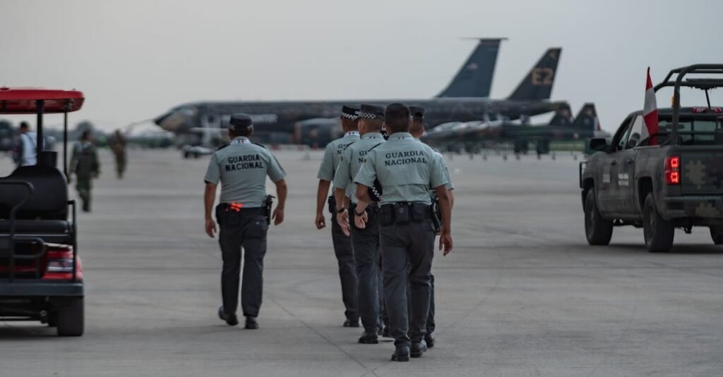 pexels-photo-19901515-19901515 National Guard officers patrolling an airport tarmac with planes in the background.