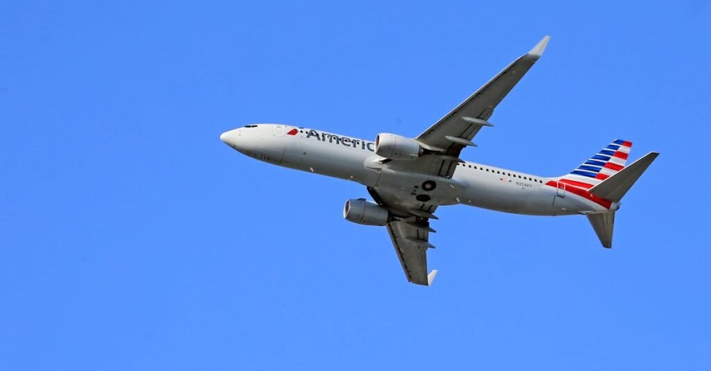 American Airlines Boeing 737 aircraft flying under a clear blue sky, showcasing aviation in motion.