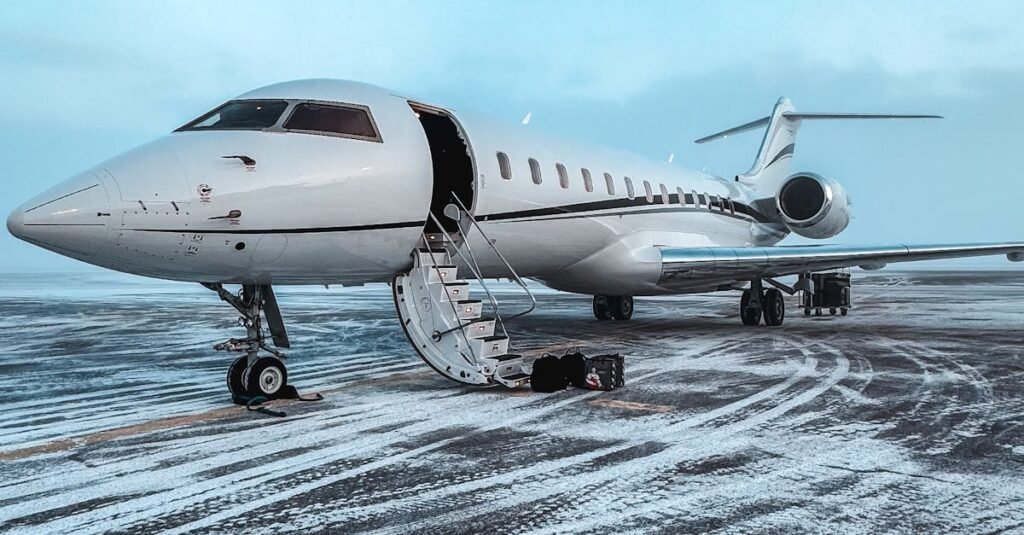 Private jet parked on a snowy airport runway during winter, clear sky.