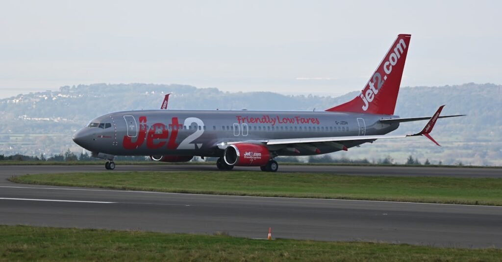 Jet2 passenger airplane taxiing at Bristol Airport with scenic backdrop.