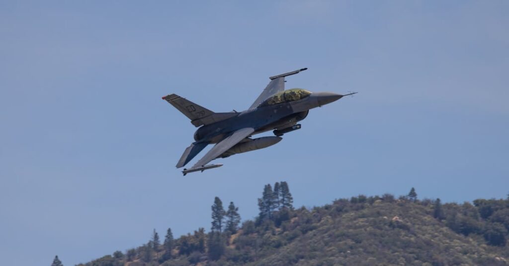 F-16 crash fighter jet flying over hills in Kernville, California, under a clear blue sky.