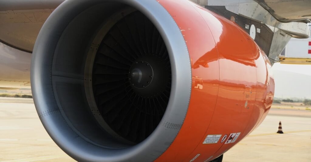 Detailed view of an orange jet engine of a commercial airplane in Sardegna, Italy.