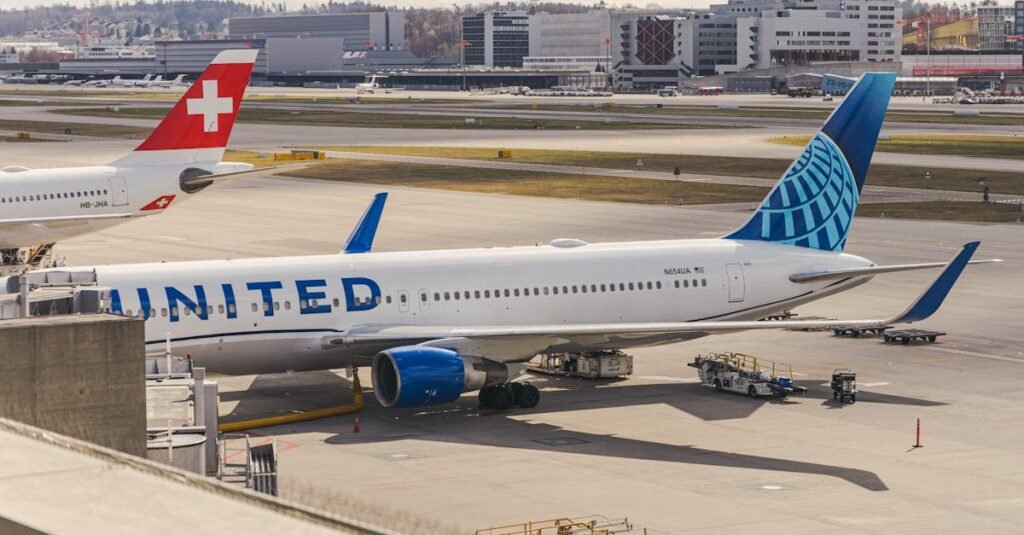United Airlines and Swiss planes parked at Zurich airport terminal on a clear day.