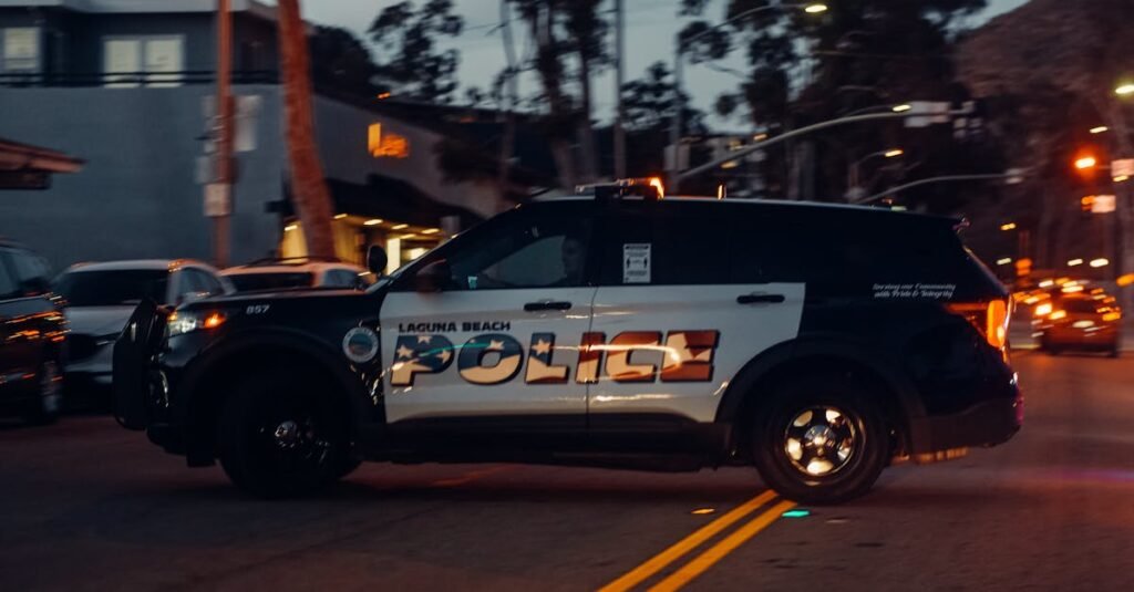 pexels-photo-7785039-7785039 Laguna Beach police vehicle patrols the street at night, showcasing law enforcement presence.