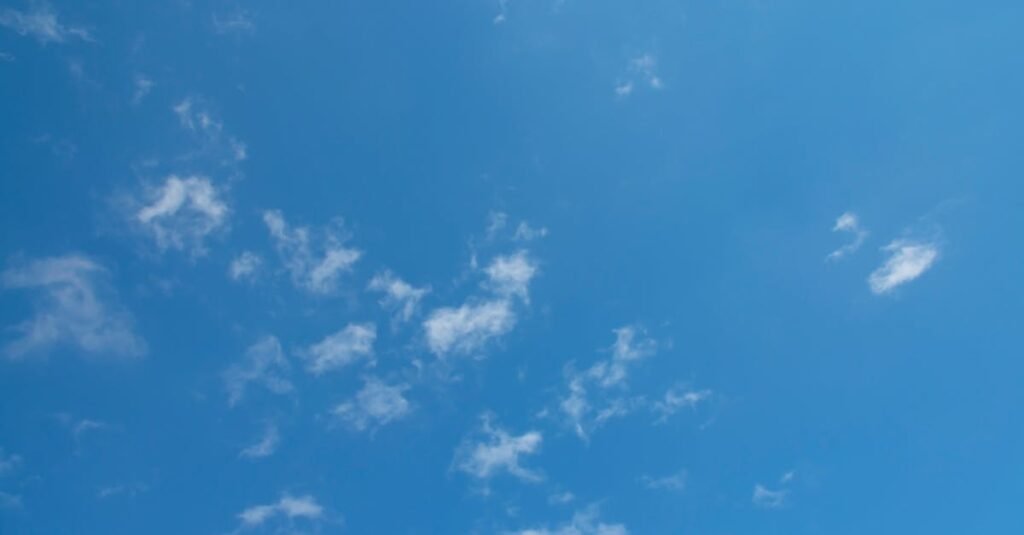 Bright blue sky with scattered fluffy white clouds creating a serene atmosphere.