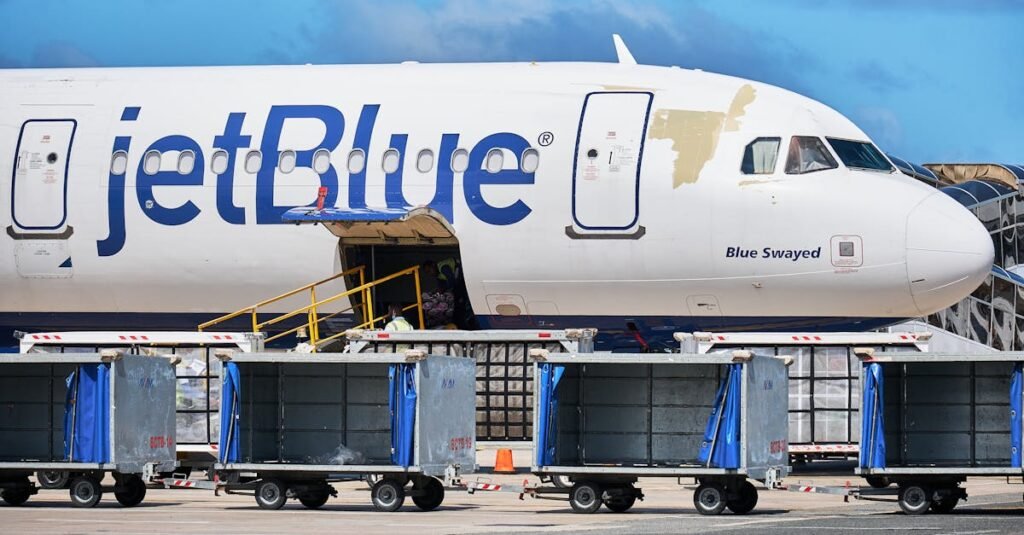 JetBlue Airbus with luggage carts at Punta Cana Airport, Dominican Republic.