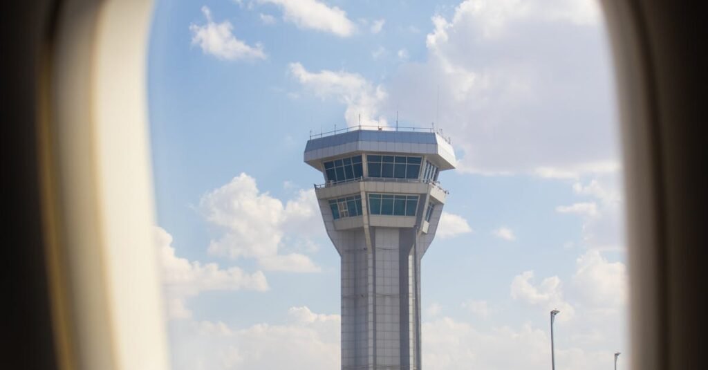 A scenic view of an air traffic control tower through an airplane window, symbolizing travel and aviation.