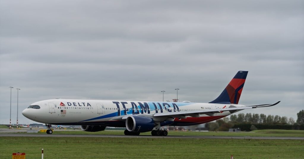 A Delta Airlines Airbus A330 with Team USA branding on a runway at an airport under cloudy skies.