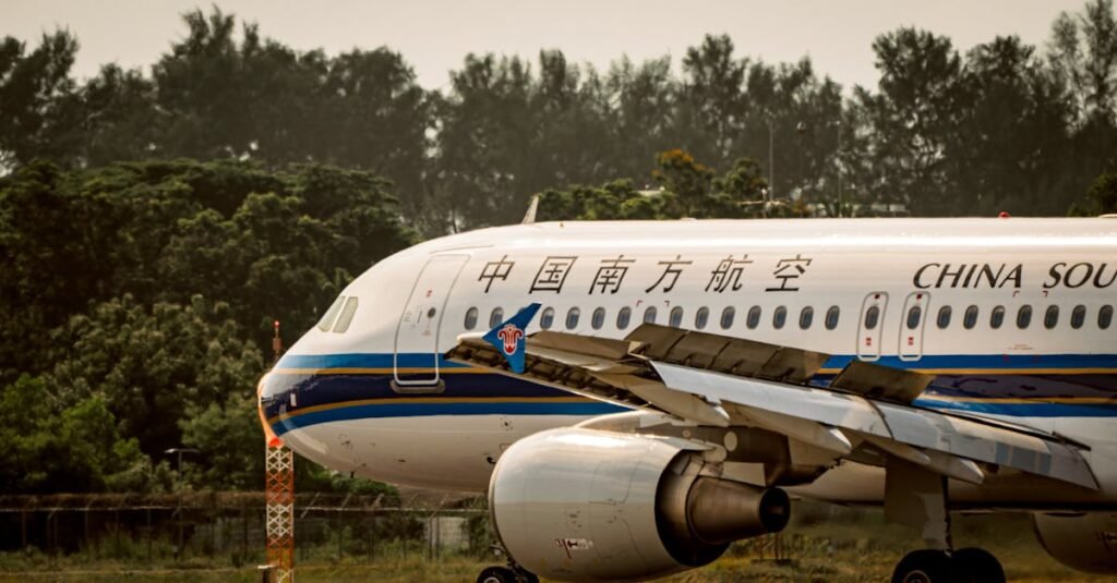 China Southern Airlines plane on runway, surrounded by lush greenery.