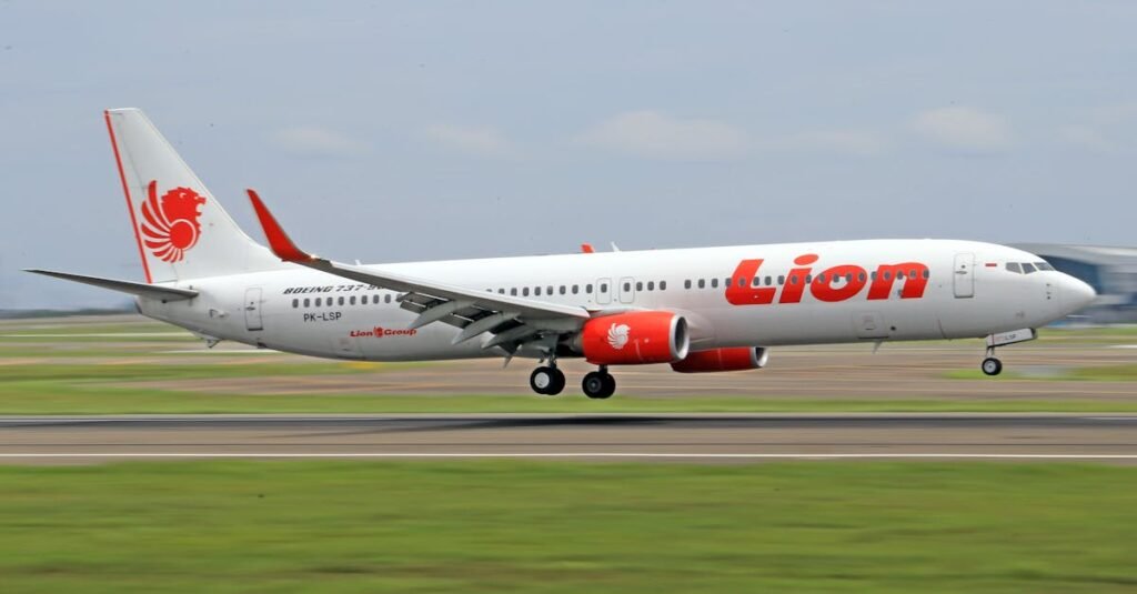 A Lion Air Boeing 737 lands smoothly on an airport runway, showcasing air travel precision.