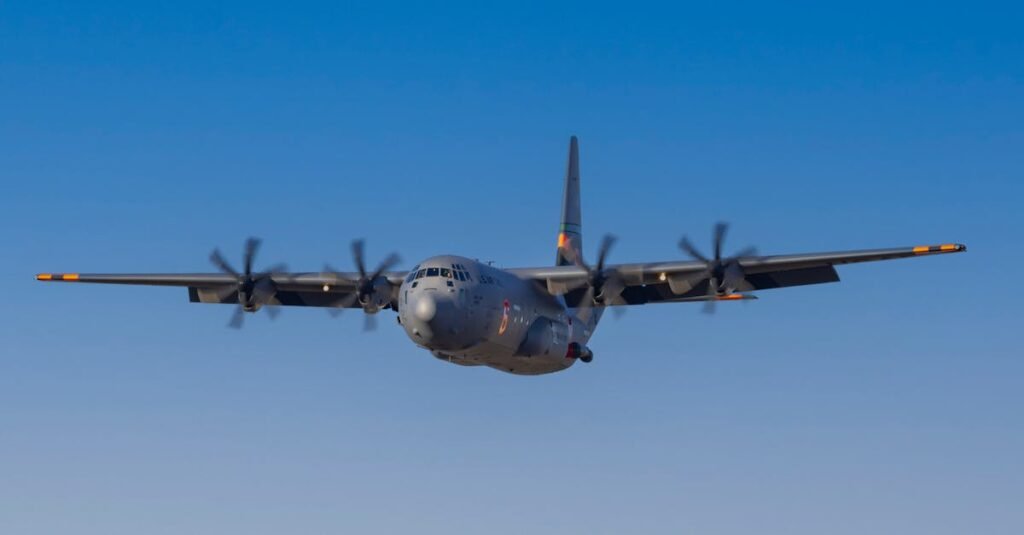 U.S. Air Force C-130 Military aircraft flying with a clear blue sky backdrop, showcasing strength and precision.