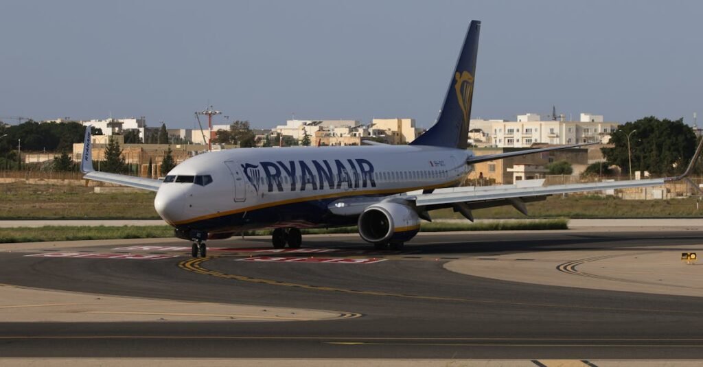 Ryanair airplane taxiing on runway in sunny weather at an airport in daylight.