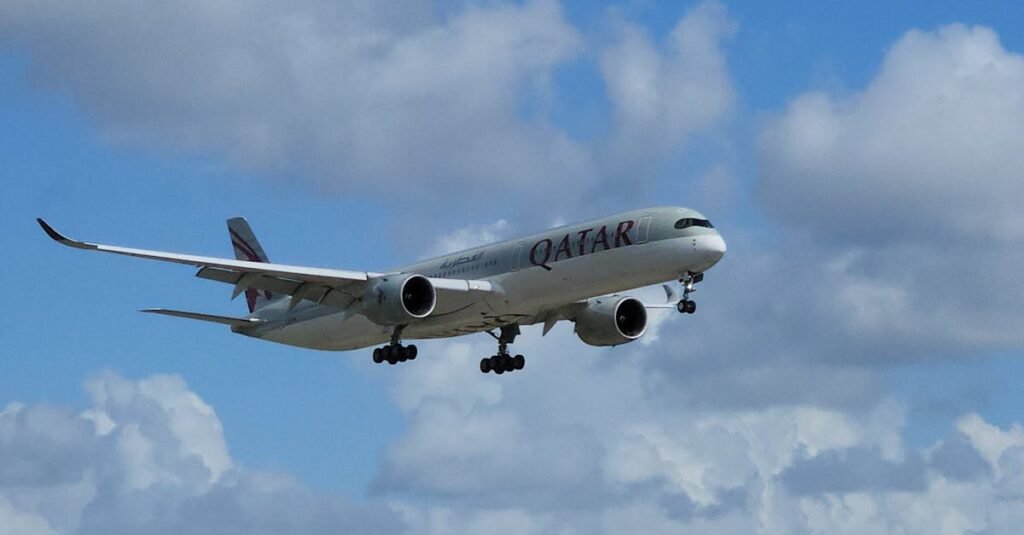 Qatar Airways Airbus A350 aircraft flying against a cloudy sky.