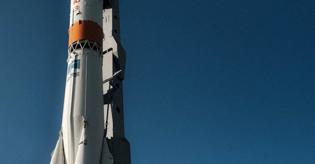 A rocket stands tall against a clear blue sky, symbolizing exploration.