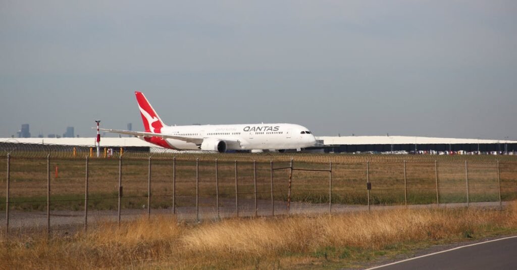 A Qantas airplane on the runway at an airport, taken on a clear day.